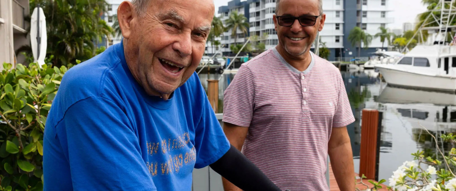 dementia patient helped by cannabis elderly man and younger man smiling on a dock in a marina